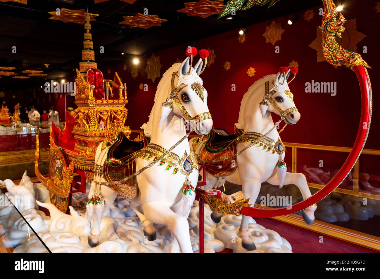 Dubai, VAE, 09.12.2021. Statue von zwei weiß verzierten Pferden, die den goldenen königlichen thailändischen Begräbniswagen (Kutsche) ziehen, im Thailand Pavilion Stockfoto