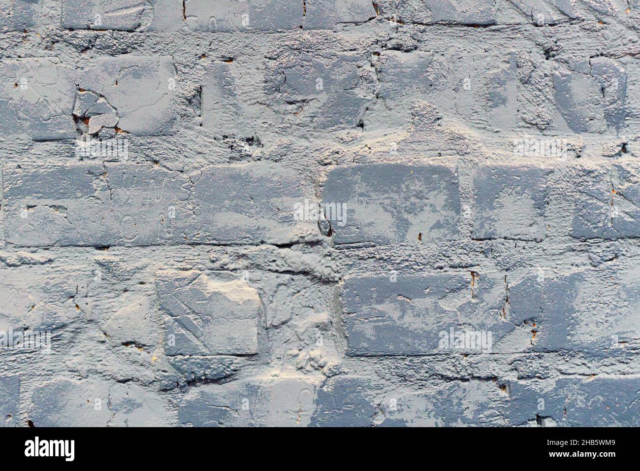 Nicht-lineares Muster aus alten, schäbigen Ziegelwänden mit natürlichen Mustern aus Farbsplittern. Grauer Backstein Wand Hintergrund Stockfoto