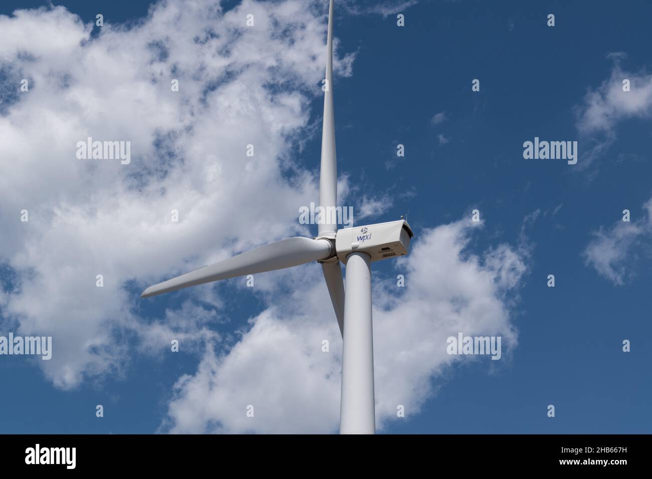Windturbinenhaus mit Propeller für die elektrische Energieerzeugung gegen bewölkten Himmel im Sommer, ökologische Alternative und erneuerbare Quellen Stockfoto