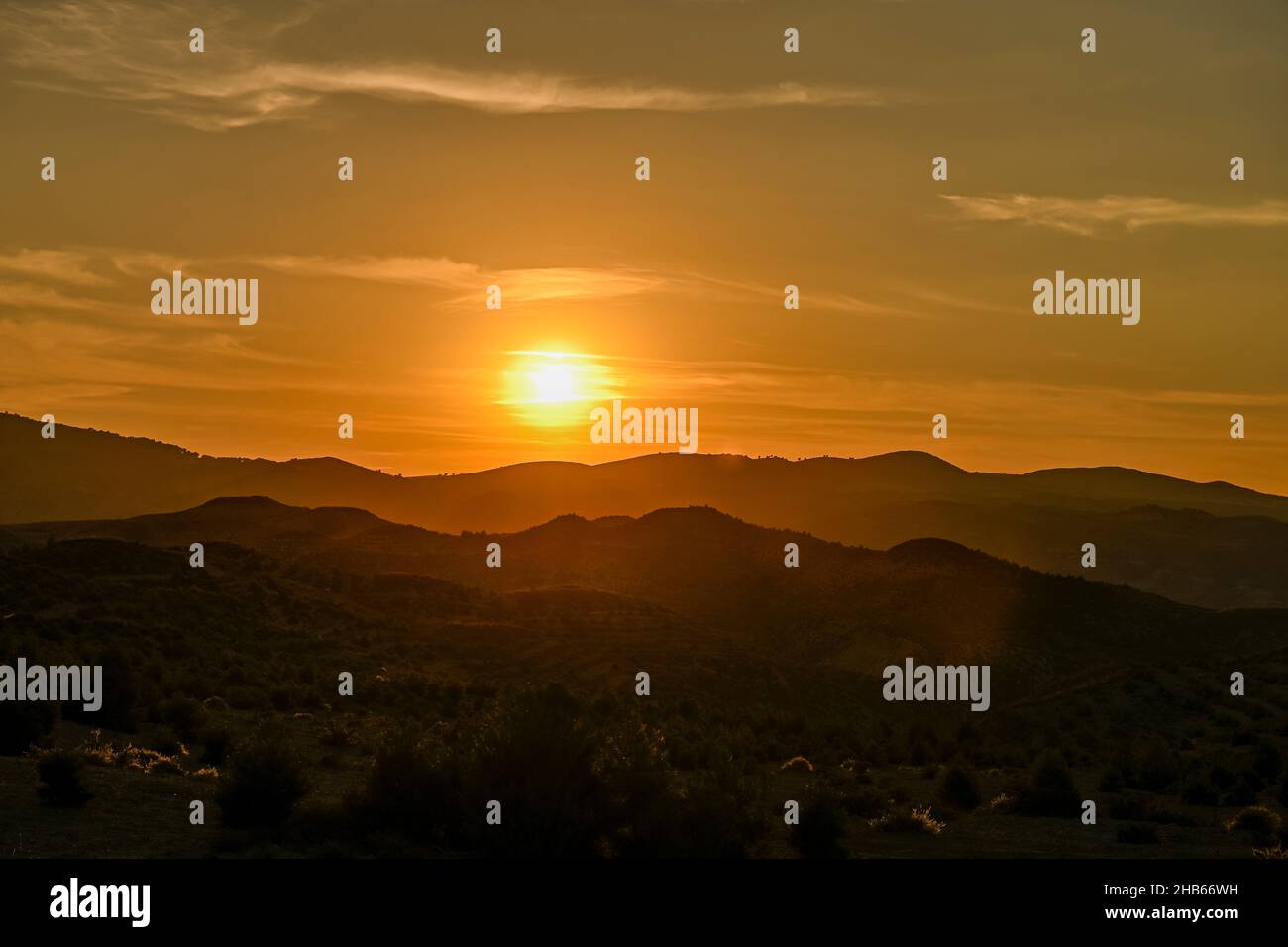 Orangefarbener Sonnenuntergang über den Bergen von Granada. Stockfoto