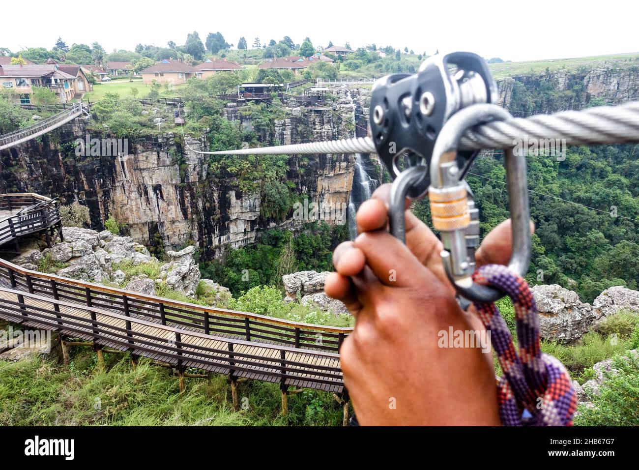 Schwarze Frau, die kurz vor einer Seilrutschen in der Graskop-Schlucht in Südafrika steht Stockfoto