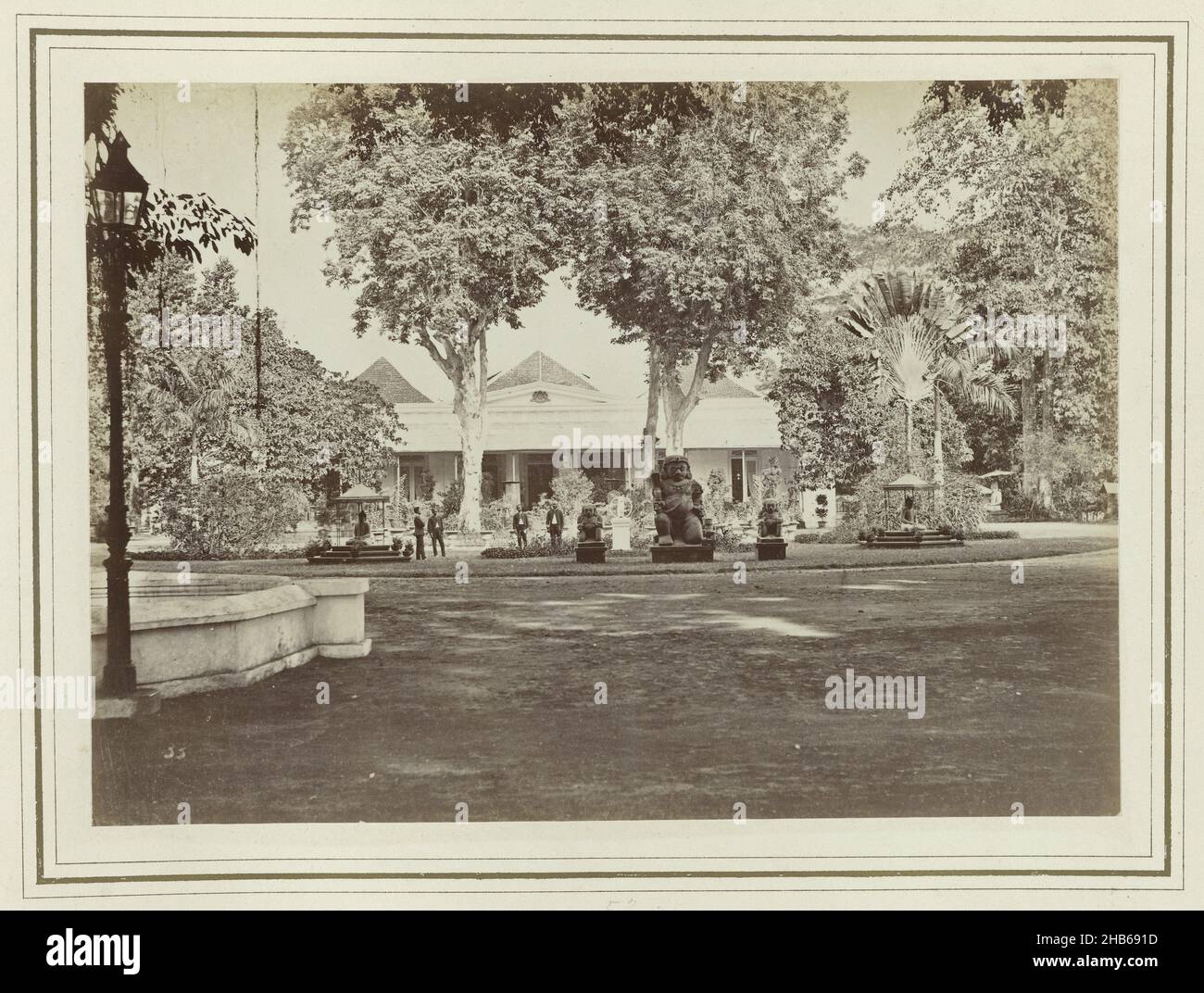 Resident's House, das Resident's House in Yogyakarta. Im Garten vor dem Haus befinden sich mehrere Statuen. Ein Teil des Fotoalbums, das J.M. vorgestellt wurde Pijnacker Hordijk über seine Abreise aus Jogyakarta im Jahr 1886., Kassian Céphas, Jogjakarta, 1886, fotografische Unterstützung, Albumin-Print, Höhe 150 mm × Breite 210 mm Stockfoto