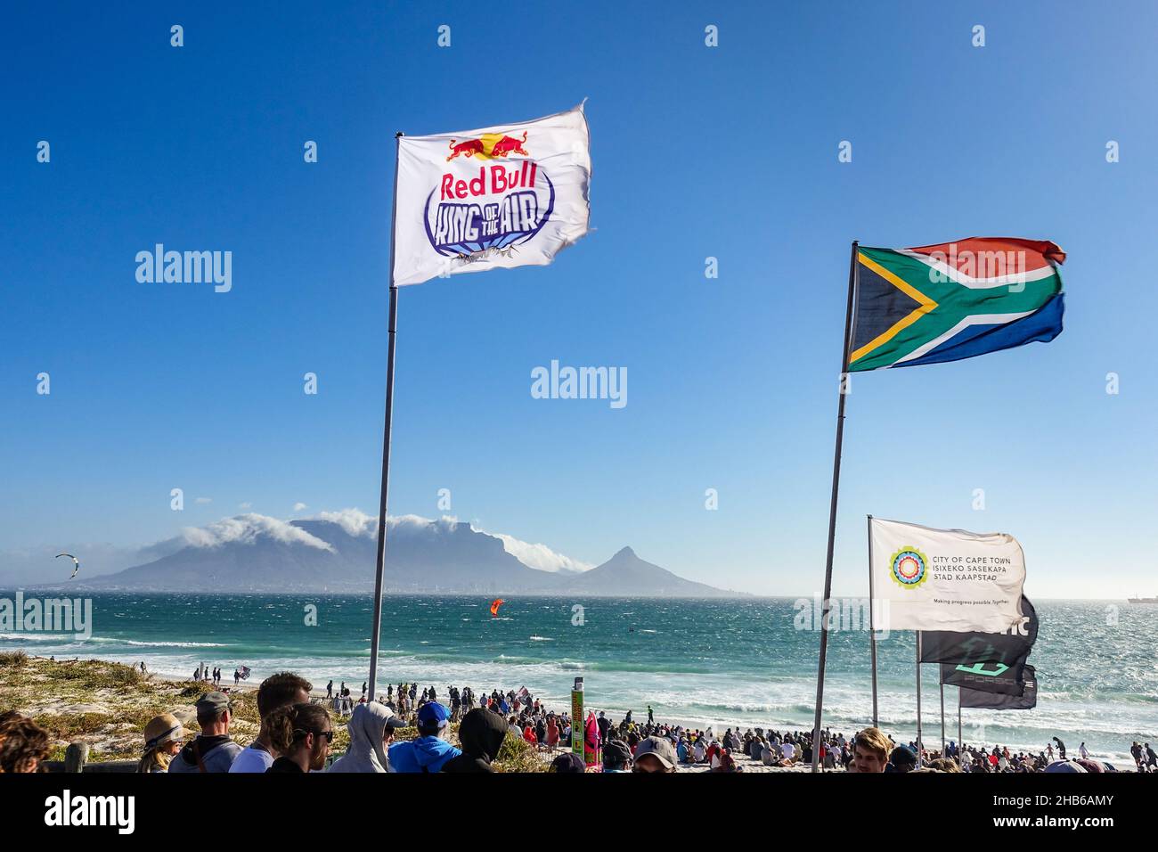Red Bull-Flagge und andere Flaggen, die während des Red Bull King of the Air 2021 in Blouberg, Kapstadt, Südafrika, in der Luft fliegen Stockfoto