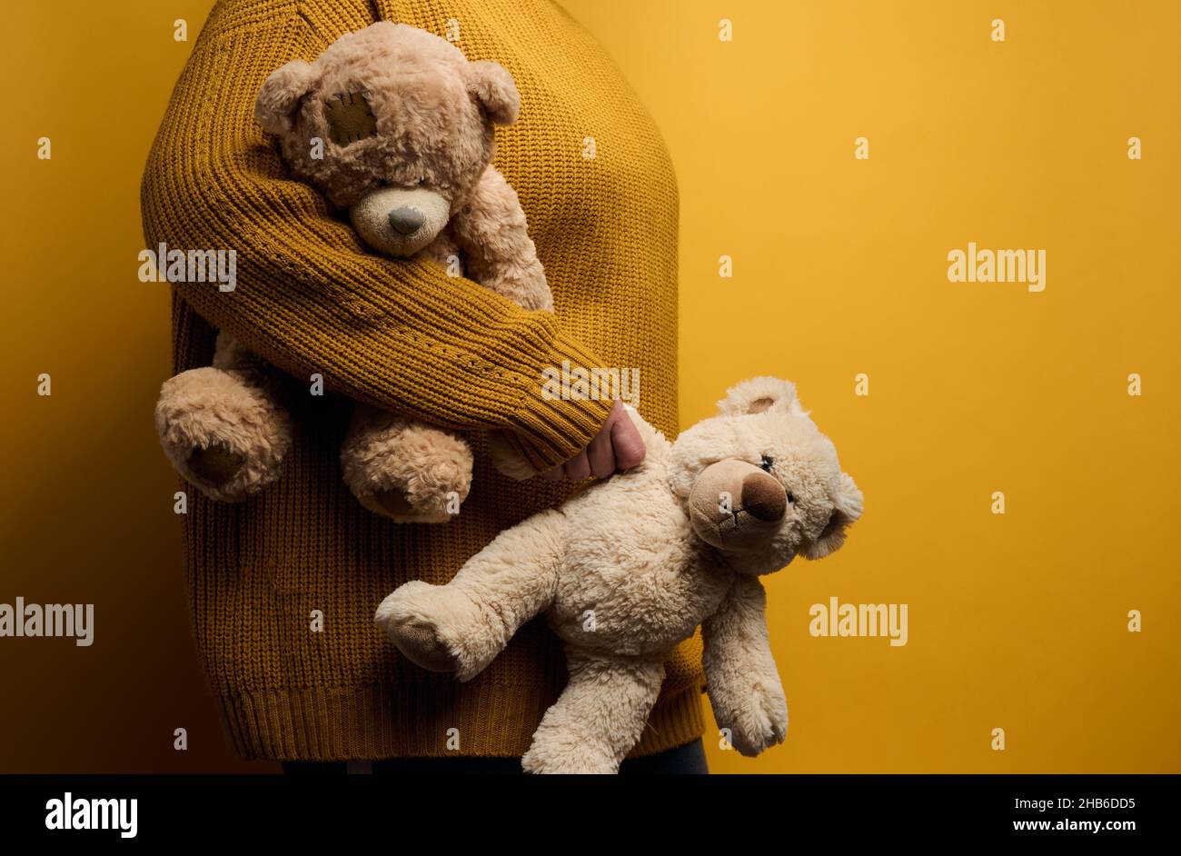 Frau in orange gestrickt Pullover Umarmungen niedlichen braunen Teddybär. Das Konzept von Einsamkeit und Traurigkeit, Depression Stockfoto