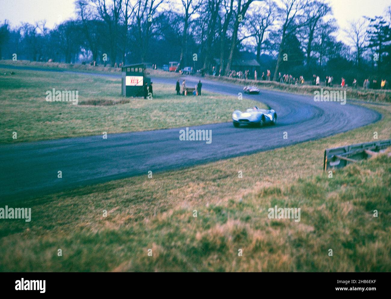 Der britische Sportrennfahrer Bill de Selincourt (1921-2014) fährt Lister-Jaguar mit einem "Knobbly"-Auto, BARC-Event auf der Rennstrecke von Oulton Park, Cheshire, England 17th. März 1962 - außer Fokus Stockfoto