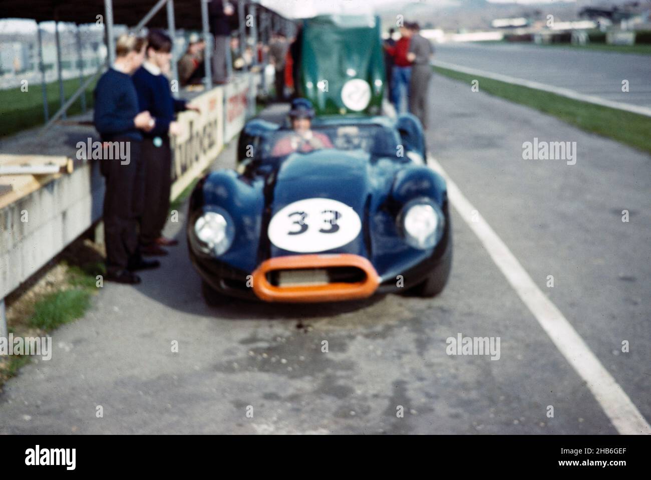Verschwommenes Foto des britischen Sportrennfahrers Bill de Selincourt (1921-2014), der Lister-Jaguar mit einem „geklopften“ Auto fährt, BARC-Event Goodwood, 1961. März in Gruben Stockfoto