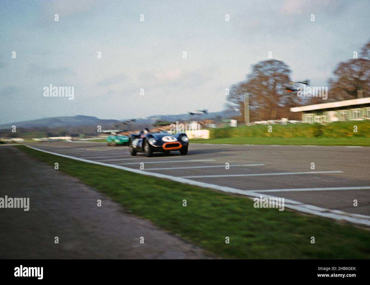 Verschwommenes Foto des britischen Sportrennfahrers Bill de Selincourt (1921-2014), der Lister-Jaguar mit einem „geklopften“ Auto fährt, BARC-Event Goodwood, März 1961 Stockfoto