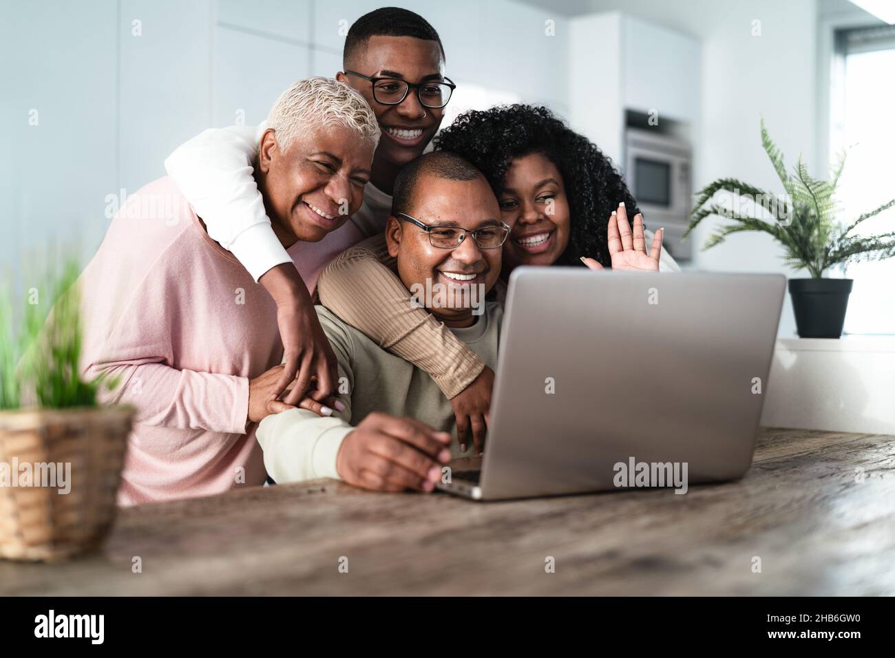 Glückliche hispanische Familie, die zu Hause mit ihren Eltern über einen Laptop telefonieren kann – Technologie- und Kommunikationskonzept Stockfoto