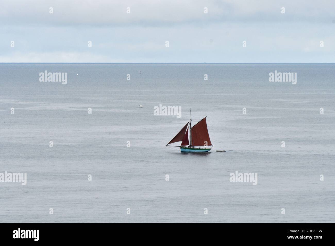Sainte Jeanne, traditionelles Segelboot mit roten Segeln, das um Erquy , Frankreich, Bretagne, Departement Cotes-d’Armor, Erquy segelt Stockfoto