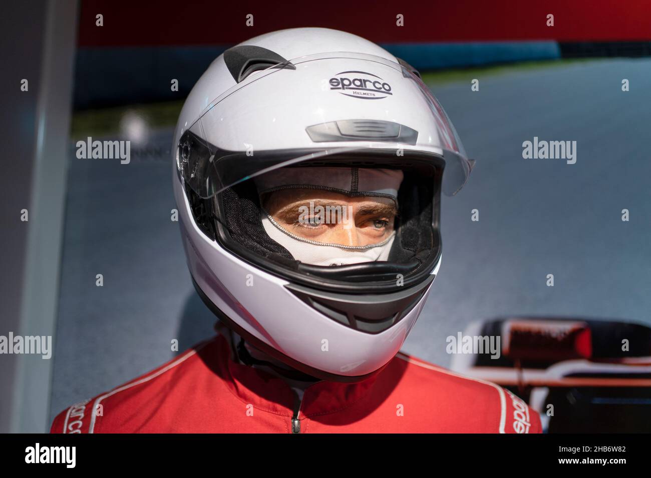 Porträt eines hübschen jungen Mannes, der einen Rennhelm trägt. Stockfoto