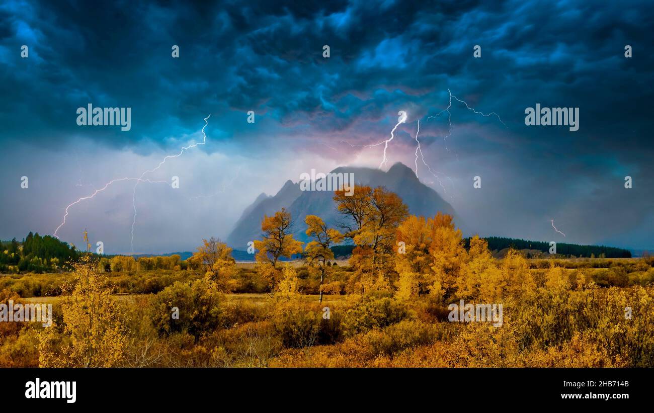 Eine surreale Herbstlandschaft mit dramatischen Wolken und Blitzen über den nebligen Teton Mountains in Jackson Hole, Wyoming, USA. Stockfoto
