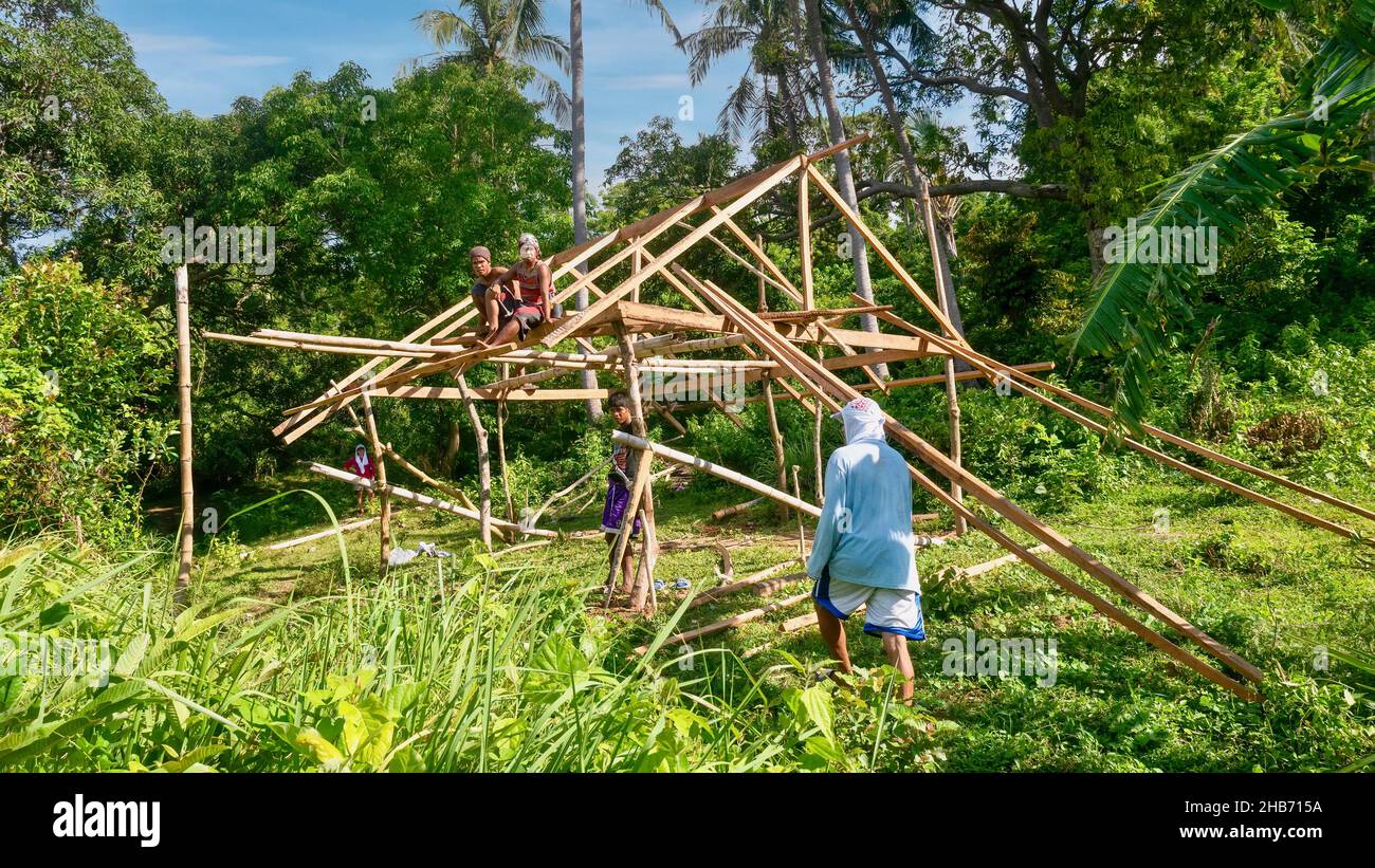 Puerto Galera, Philippinen - 19. Juni 2021. Eine kleine Arbeitercrew aus indigenen Mangyanern, die ein kleines, einfaches Haus an Land ohne Strom bauen. Stockfoto