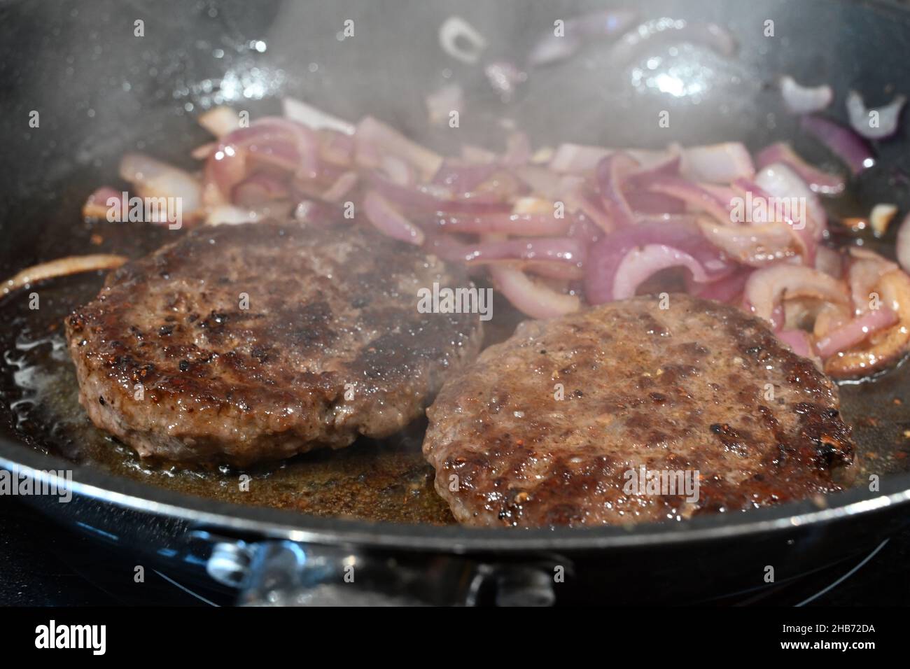 Burger Kochen in der Pfanne aus nächster Nähe Stockfotografie - Alamy