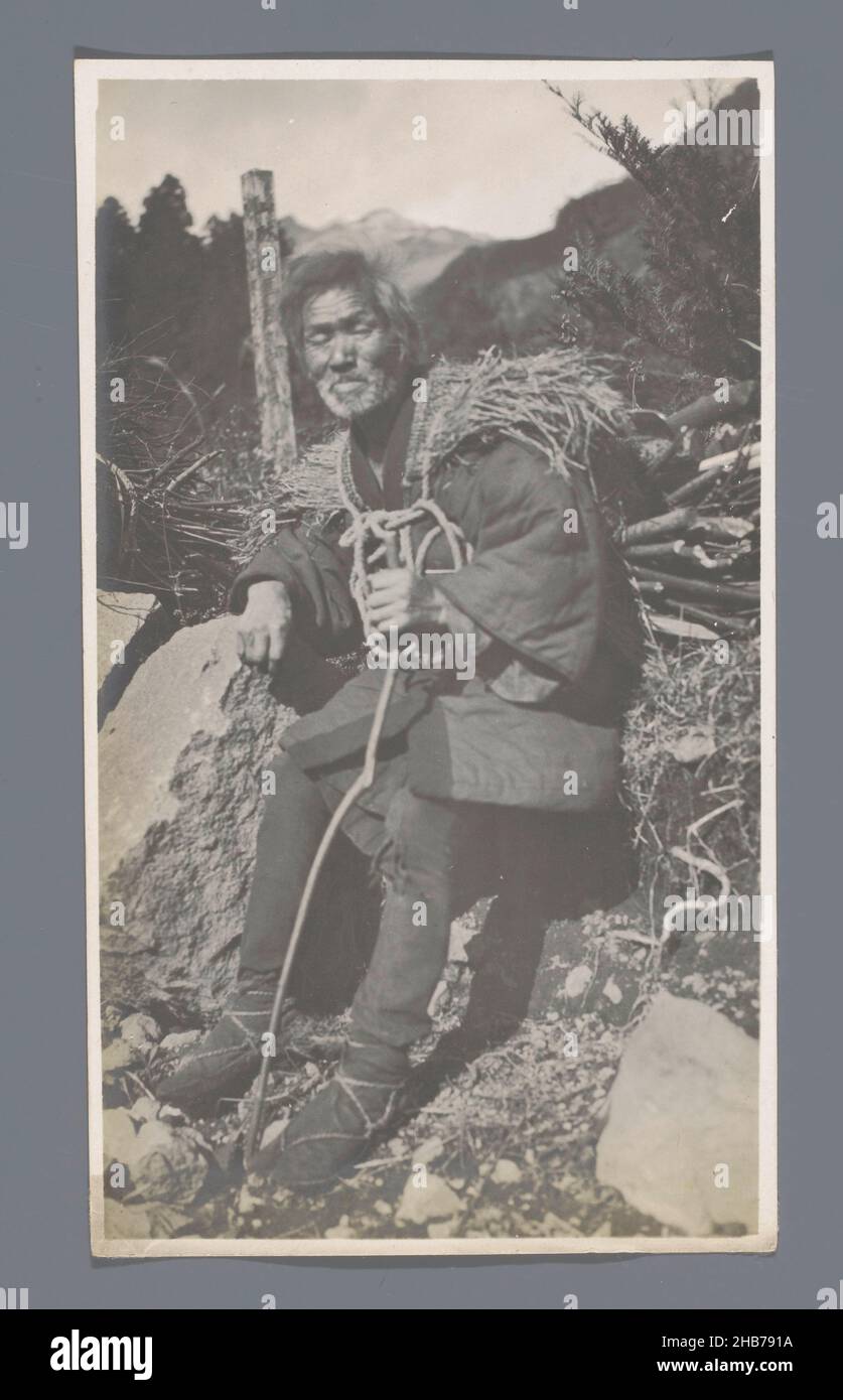 Porträt eines Japaners mit einem Haufen Ästen, ruhend am Straßenrand, Nikko, Japan, Jan Adriani (Kreis), Japan, 1907, Papier, Silbergelatine-Druck, Höhe 137 mm × Breite 77 mm Stockfoto