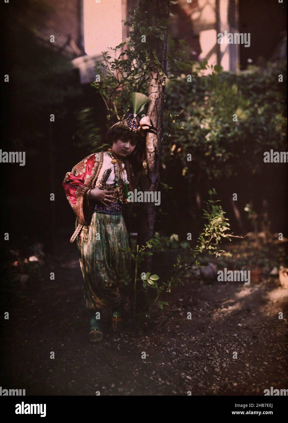Kind in orientalischer Tracht, lehnt an einen Baum, anonym, c. 1910 - c. 1940, Glas, Höhe 240 mm × Breite 180 mm Stockfoto