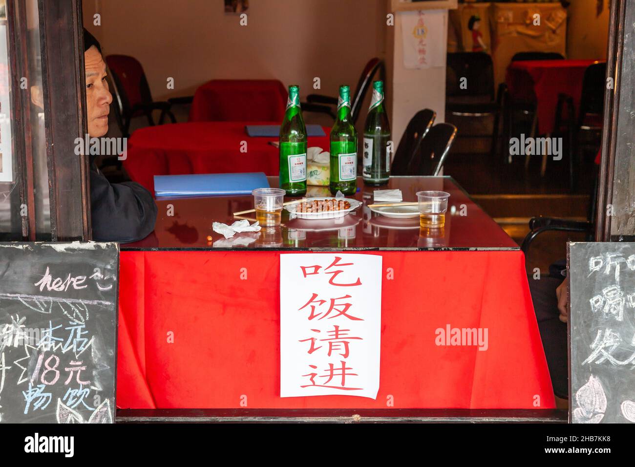 Mann am Tisch, der nach dem Essen träumt. Xitang, China Stockfoto