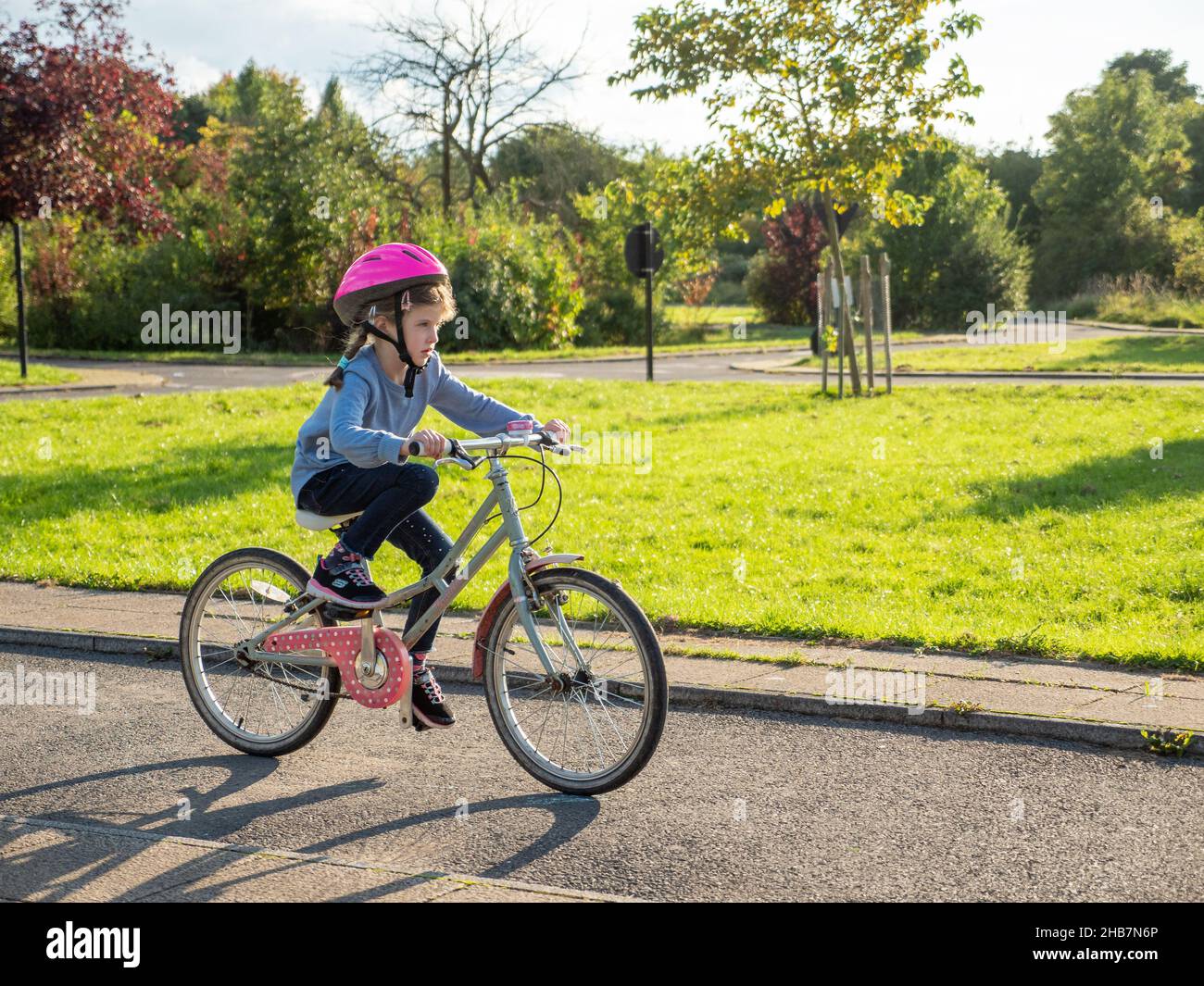 Kind, das mit dem Fahrrad auf dem Model Traffic Area in Lordship Recreation Ground, Haringey, London, Großbritannien, unterwegs ist Stockfoto