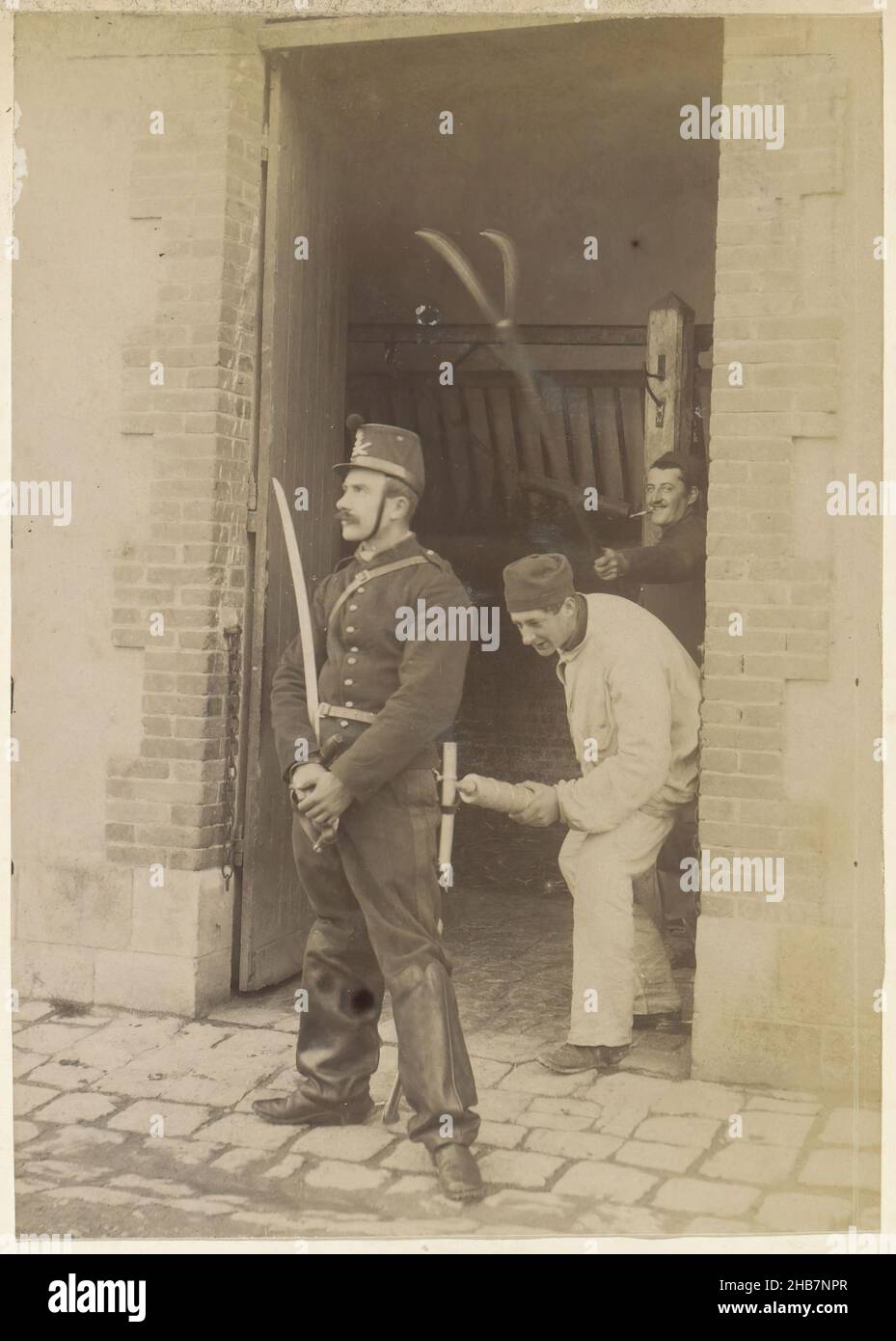 Militärmänner belagern Wache als Witz mit Pitchfork und Pisser in Frankreich, Teil des Fotoalbums eines französischen Amateurfotografen mit Aufnahmen einer Familie, Brennerei Delizy &amp; Doistau Fils, der Armee und Sehenswürdigkeiten in Frankreich., anonym, Frankreich, c. 1900 - c. 1910, Papier, Albumin-Druck, Höhe 147 mm × Breite 105 mm Stockfoto