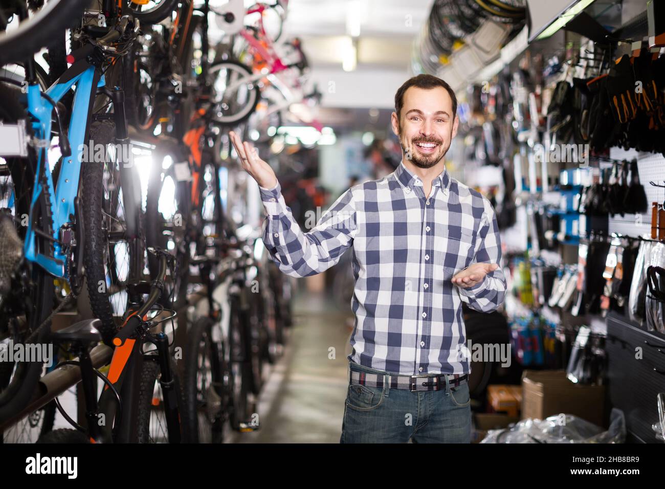 Der Mensch zeigt seine Hand und sieht sich verschiedene Fahrradteile an Stockfoto