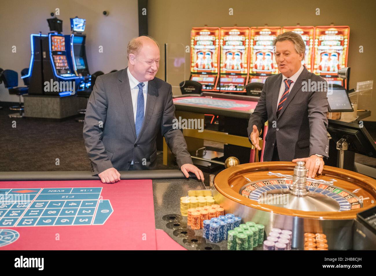 Braunschweig, Deutschland. 17th Dez 2021. Niedersachsens Finanzminister Reinhold Hilbers (CDU, l) geht mit dem Casino-Geschäftsführer Max Rösle während der Eröffnungsfeier durch das neue Casino in Braunschweig. Das Braunschweiger Casino bietet Roulette-, Poker-, Black Jack- und Glücksspielautomaten auf einer Gesamtfläche von 1300 m2 Spielern. Quelle: Ole Spata/dpa/Alamy Live News Stockfoto