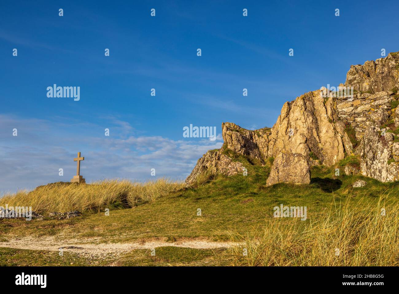 Das Kreuz und die Felsen von St. Dwynwen auf Llanddwyn Island, Isle of Anglesey, Nordwales Stockfoto