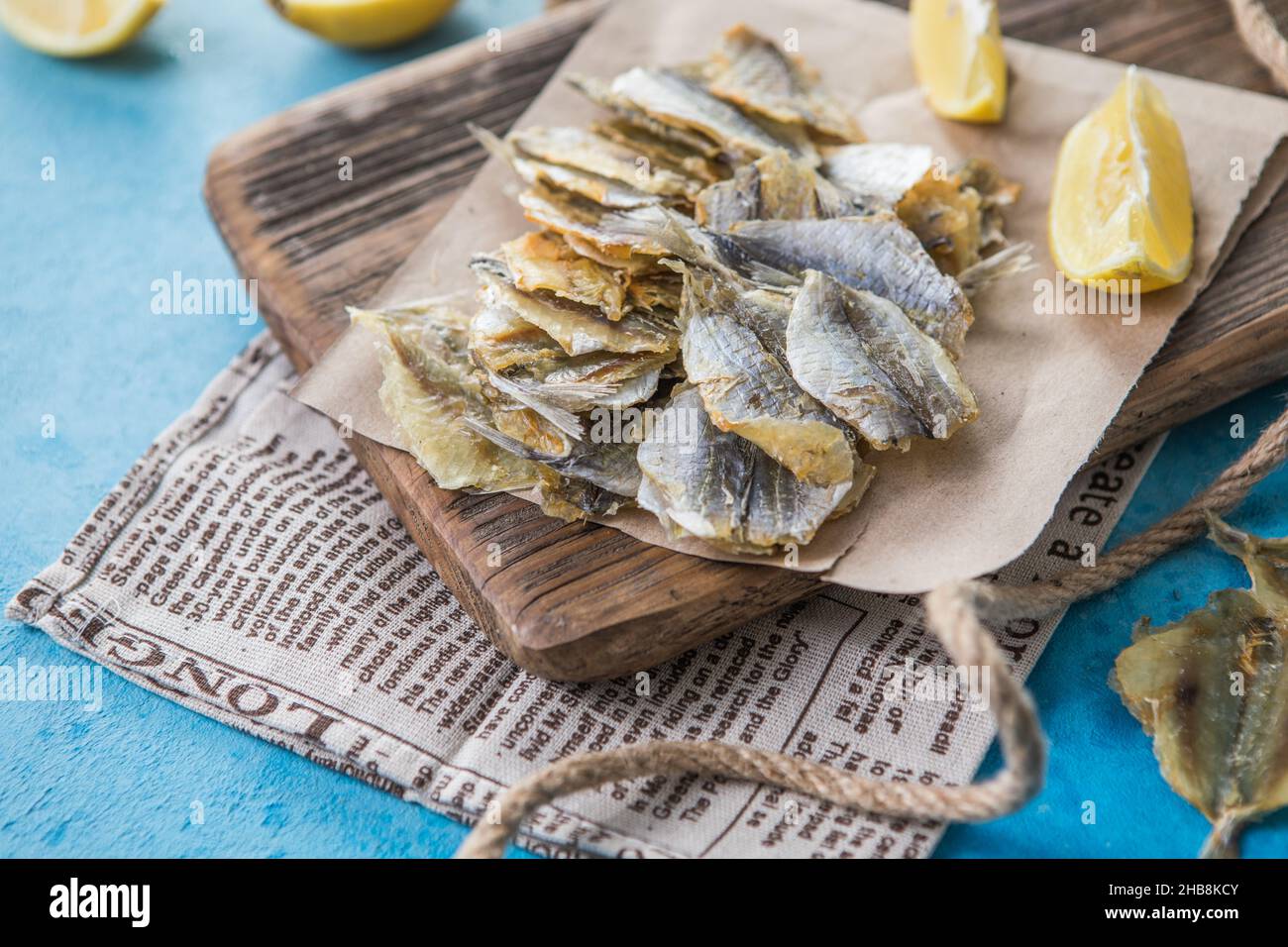 Getrocknete gelbe Zwergwale auf blauem Hintergrund. Biersnack, getrocknete Meeresfrüchte. Industrieller Fang, Schablone Stockfoto