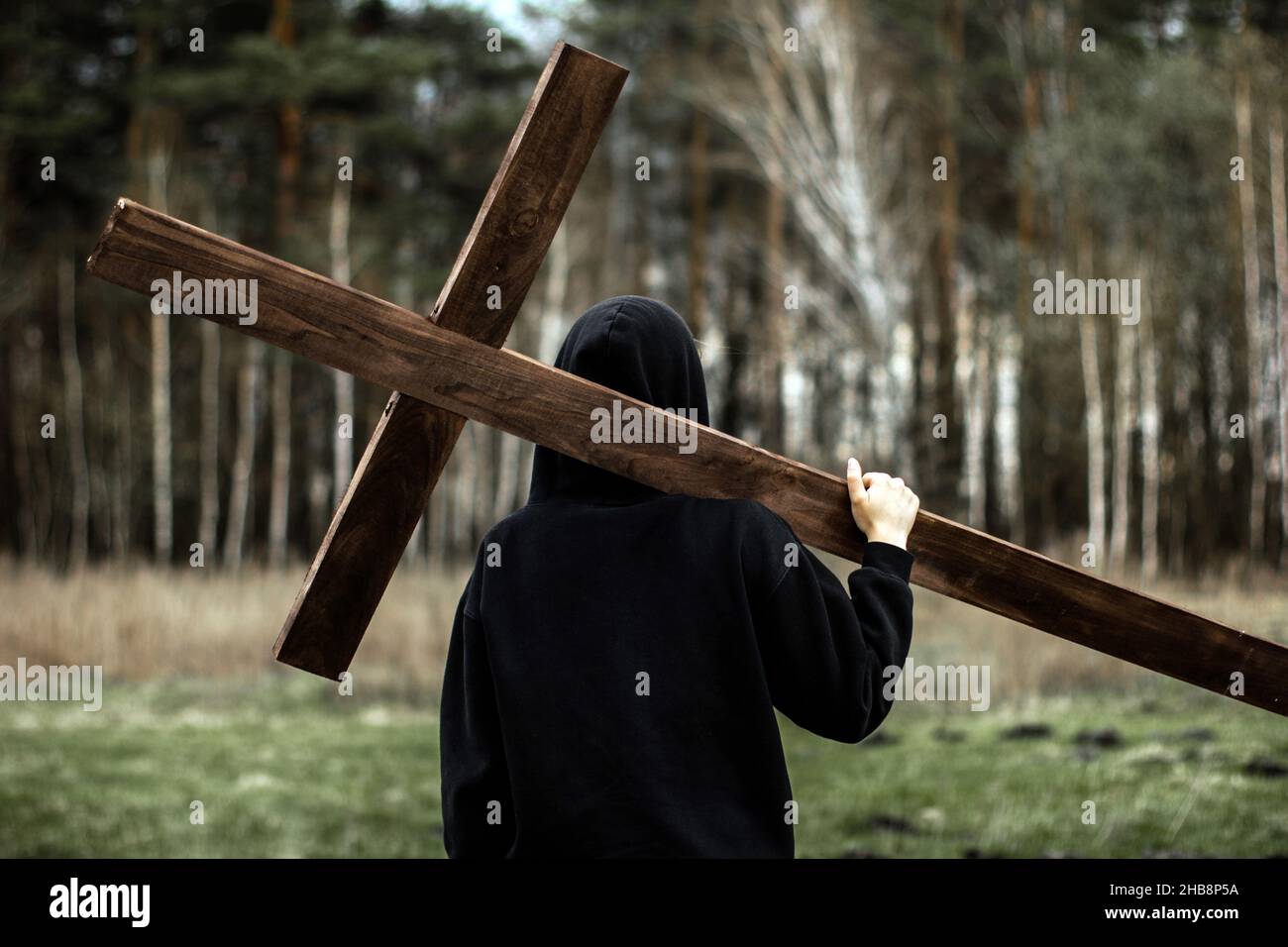 Das Mädchen trägt das Kreuz. Das Kreuz tragen. Der Mensch glaubt an Gott. Hoffnung auf Gott. Stockfoto