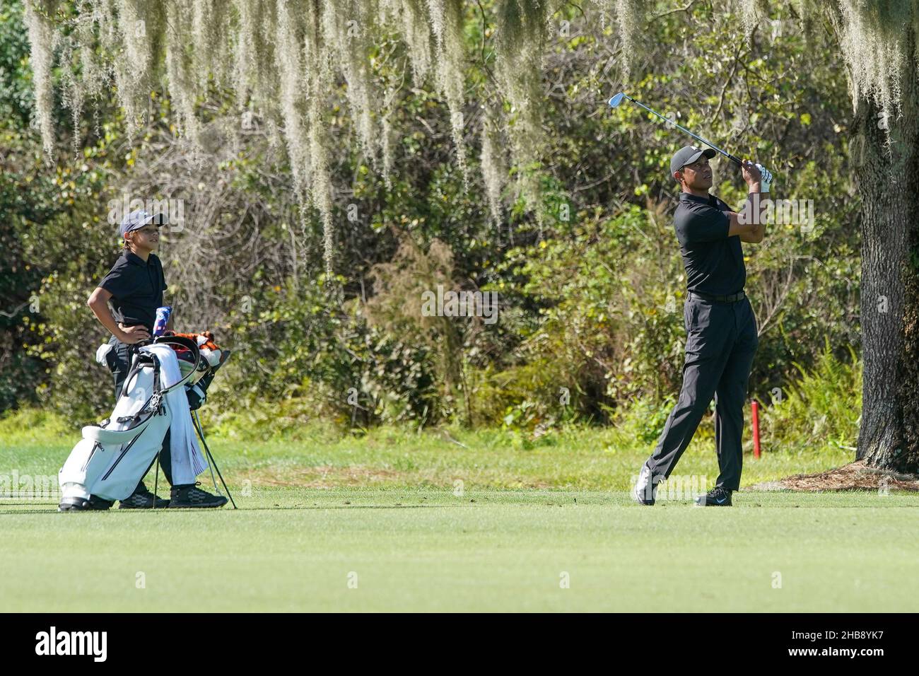 Orlando, Florida, USA. 17th Dez 2021. Tiger Woods (R) trifft eine Fairway-Aufnahme, während Sohn Charlie Woods während der PNC-Meisterschaft im Ritz-Carlton Golf Club in Orlando, Florida, aufschaut. Kredit: ZUMA Press, Inc./Alamy Live Nachrichten Stockfoto