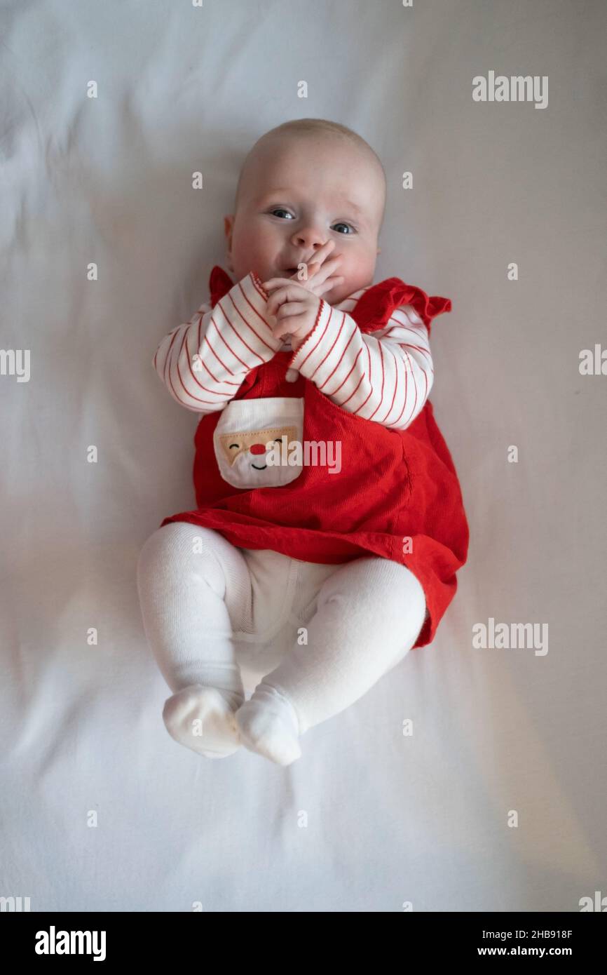 Niedliche kaukasische Baby-Mädchen in roten weihnachtskleid gekleidet Blick  auf die Kamera Stockfotografie - Alamy