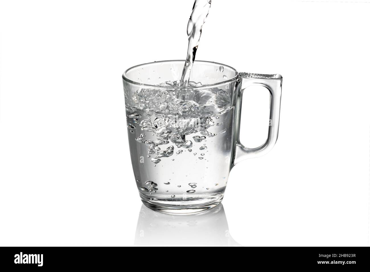 Frisches Wasser in Glas mit Griff, isoliert auf weiß Stockfoto