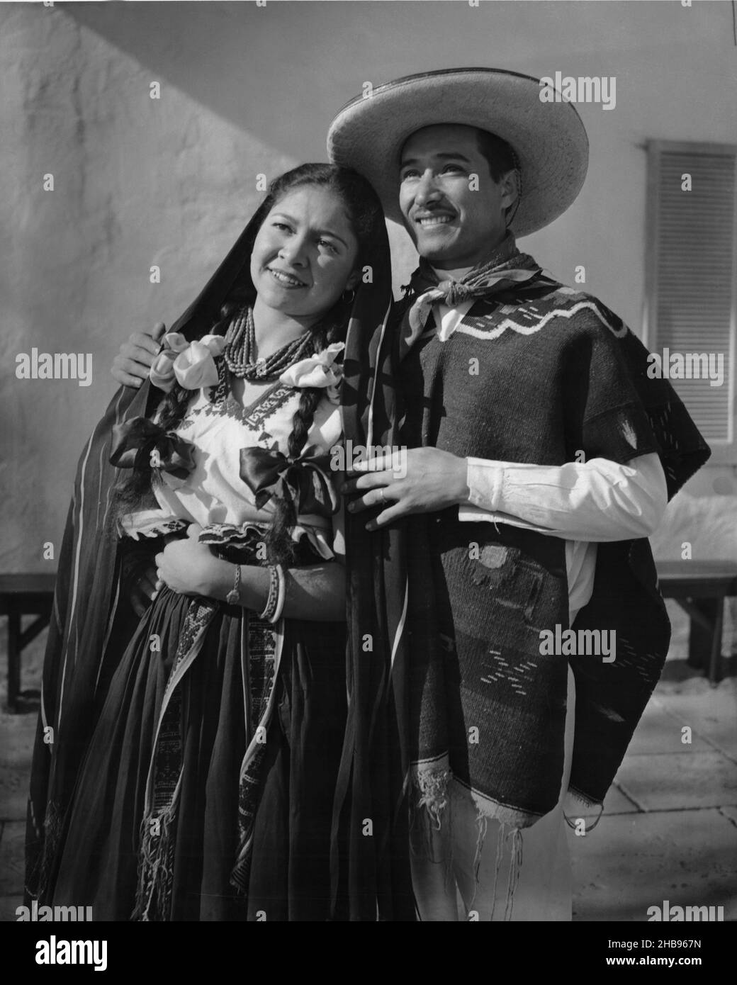 Mann und Frau Mitte der 30er Jahre in traditioneller Kleidung, die beim Ausblicken posieren. Ca. 1955 Stockfoto