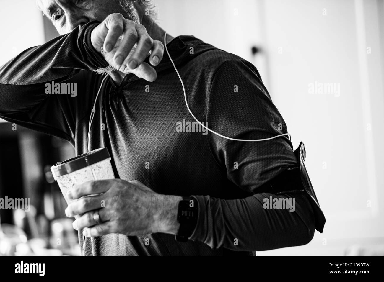 Älterer Mann trinkt nach einem Lauf in seiner Küche einen Smoothie Stockfoto