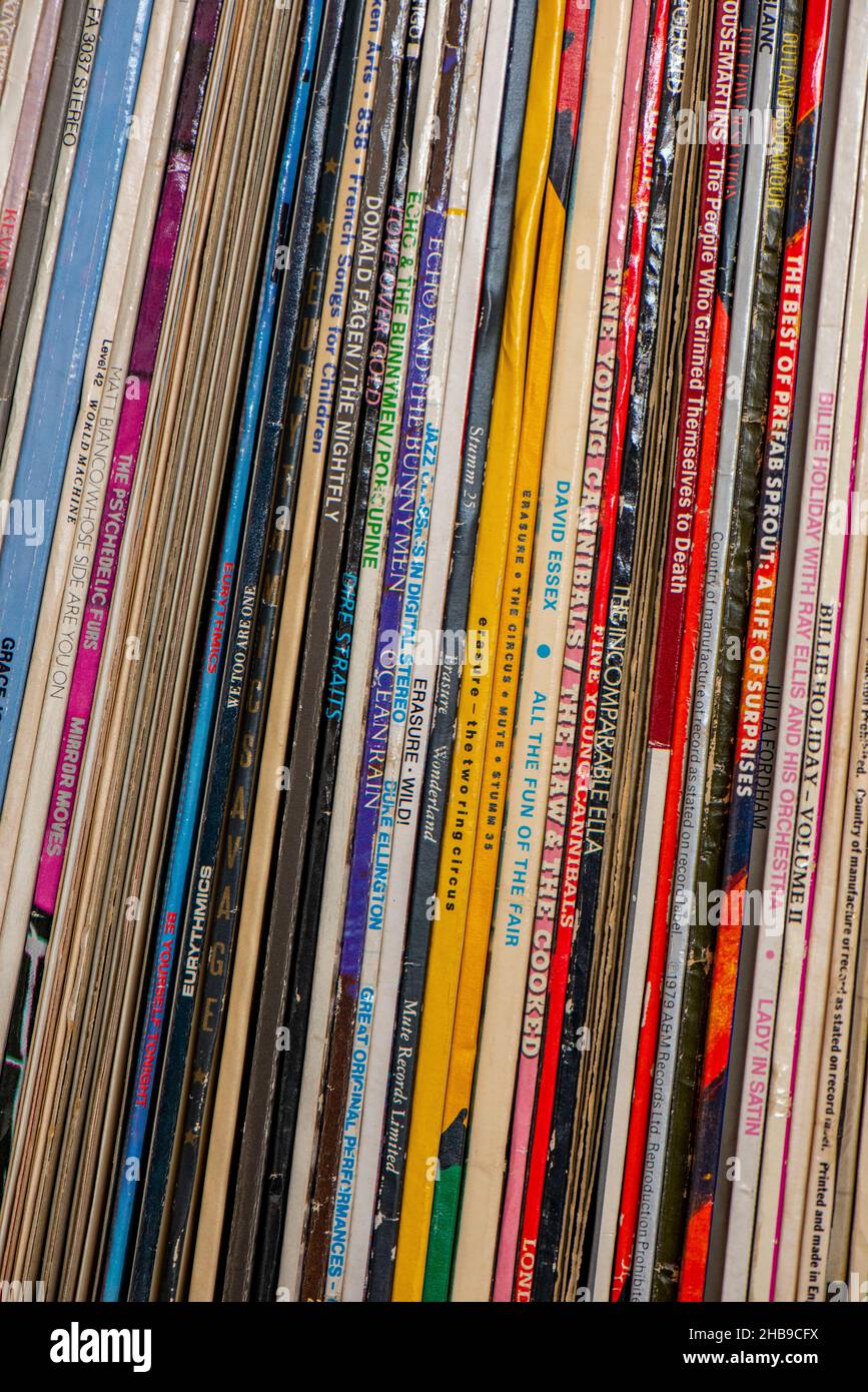 Auswahl von 33rpm lang spielenden Vinylplatten auf einem Regal, alte Vinylmusik-Aufnahmen in bildhaften Papphüllen auf dem Regal. Stockfoto