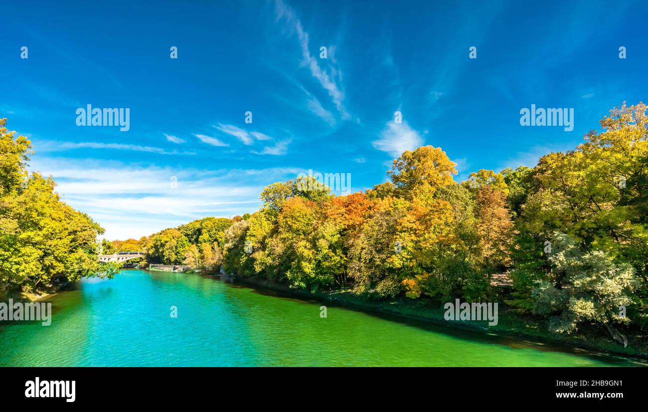 Blick auf die Isar und bunte Bäume in der Herbstlandschaft in München Stockfoto