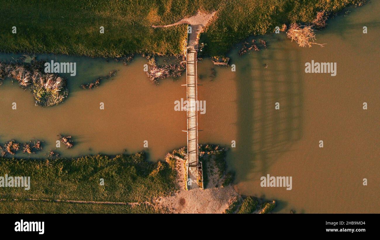 Drohnenaufnahme einer öffentlichen Fußgängerbrücke in den Sudbury Wasserwiesen. Aufgenommen am späten Winternachmittag von einem Aussichtspunkt direkt über dem Hotel. Stockfoto