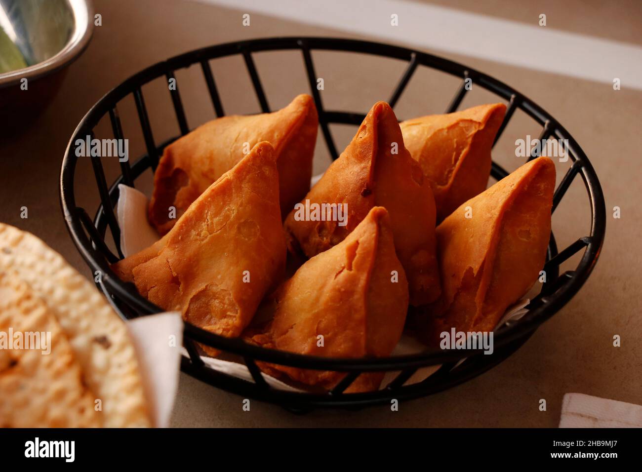 Indischer Snack punjabi samosa mit Minze und Tamarindensauce, gefüllter, frittierter Kartoffelteig Stockfoto