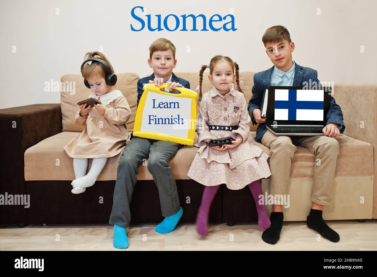 Vier Kinder zeigen die Inschrift finnisch lernen. Fremdsprachenlernkonzept. Suomea. Stockfoto