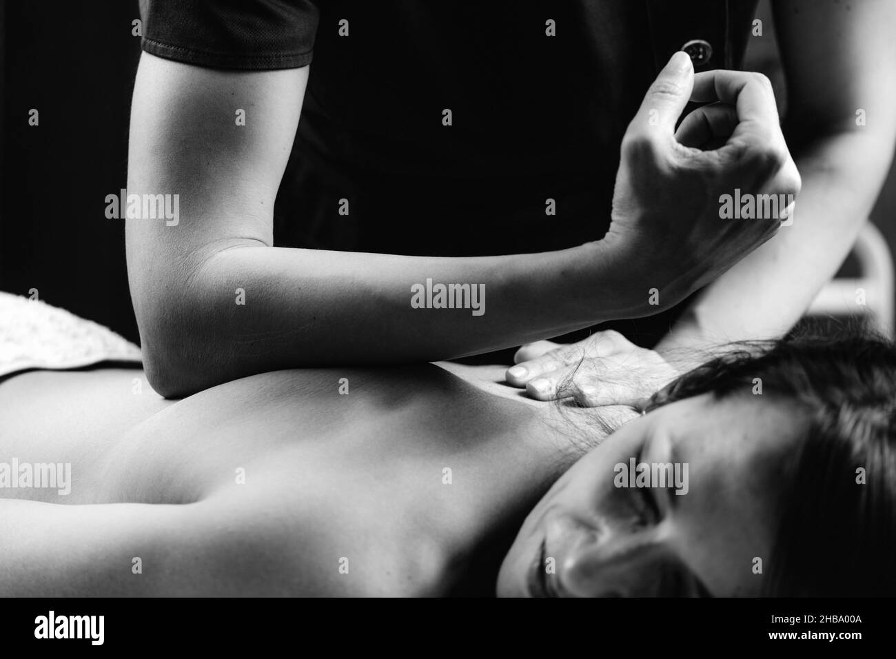 Tiefengewebsmassage. Therapeut massiert den Rücken der Frau mit Ellenbogendruck. Stockfoto