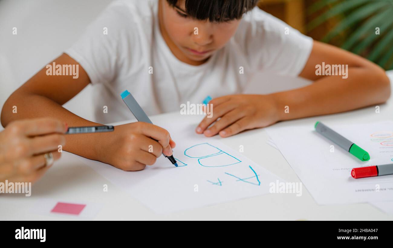 Junge, der bei einem Vorschulscreening Briefe schreibt. Stockfoto