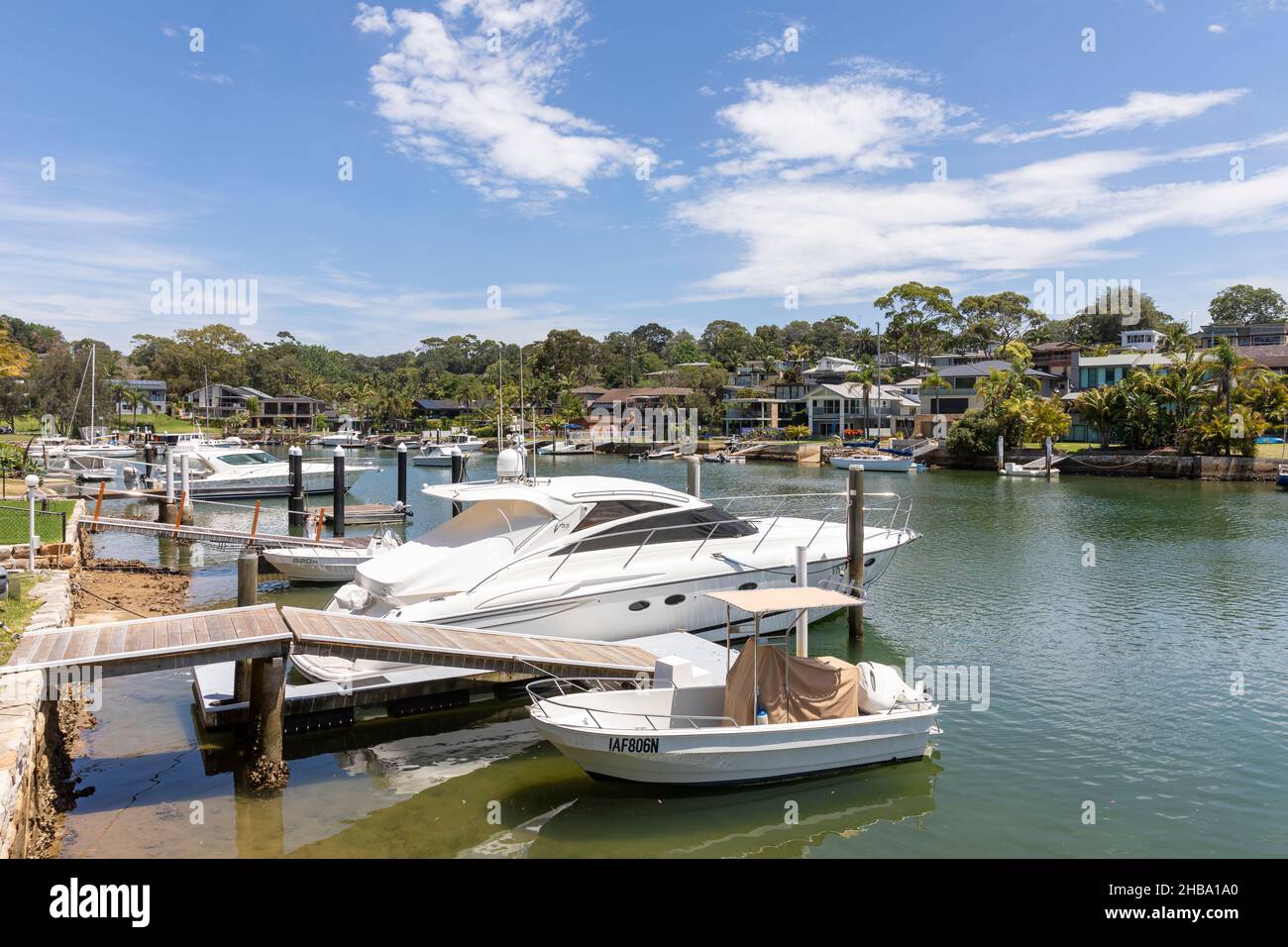 Häuser am Wasser in Newport Sydney, mit privaten Anlegestellen und Hausbesitzern mit ihren Booten, Pittwater, NSW, Australien Stockfoto