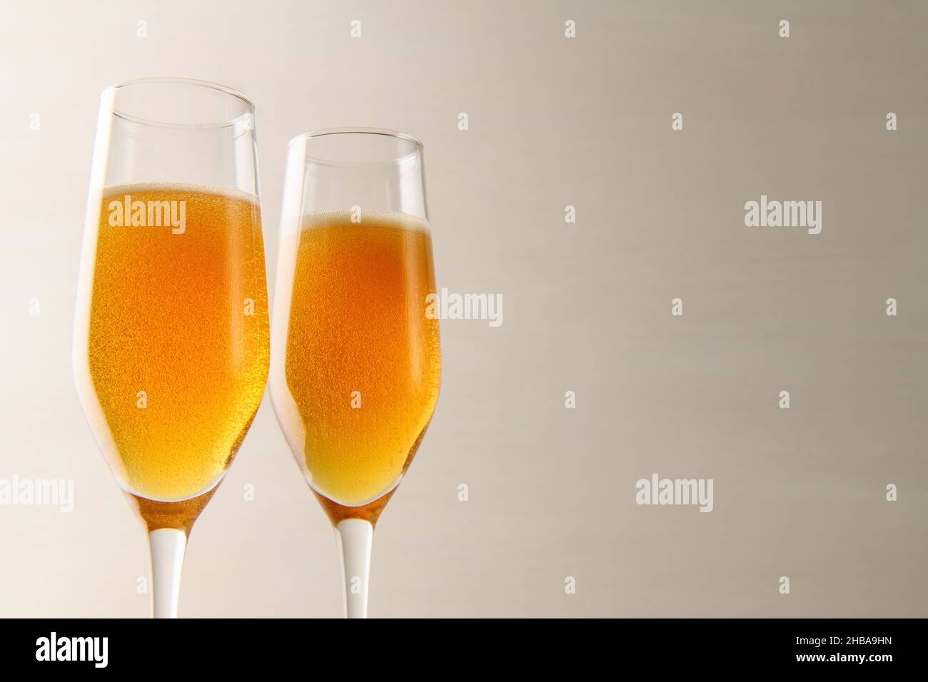 Zwei Gläser Champagner mit Blasen auf grauem Hintergrund. Neujahr und Weihnachten Hintergrund. Valentinstag Stockfoto