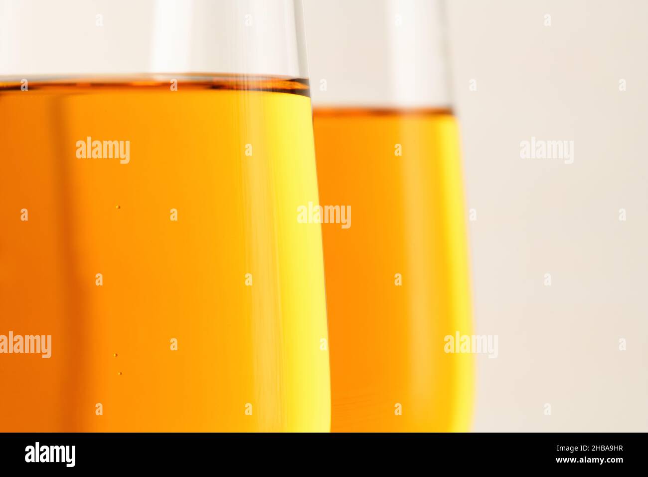 Unscharfer Hintergrund. Zwei Gläser Champagner, Wein auf grauem Hintergrund. Alkoholisches Getränk: Champagner, Bier, Weißwein. Neujahr und Weihnachten Backgrou Stockfoto