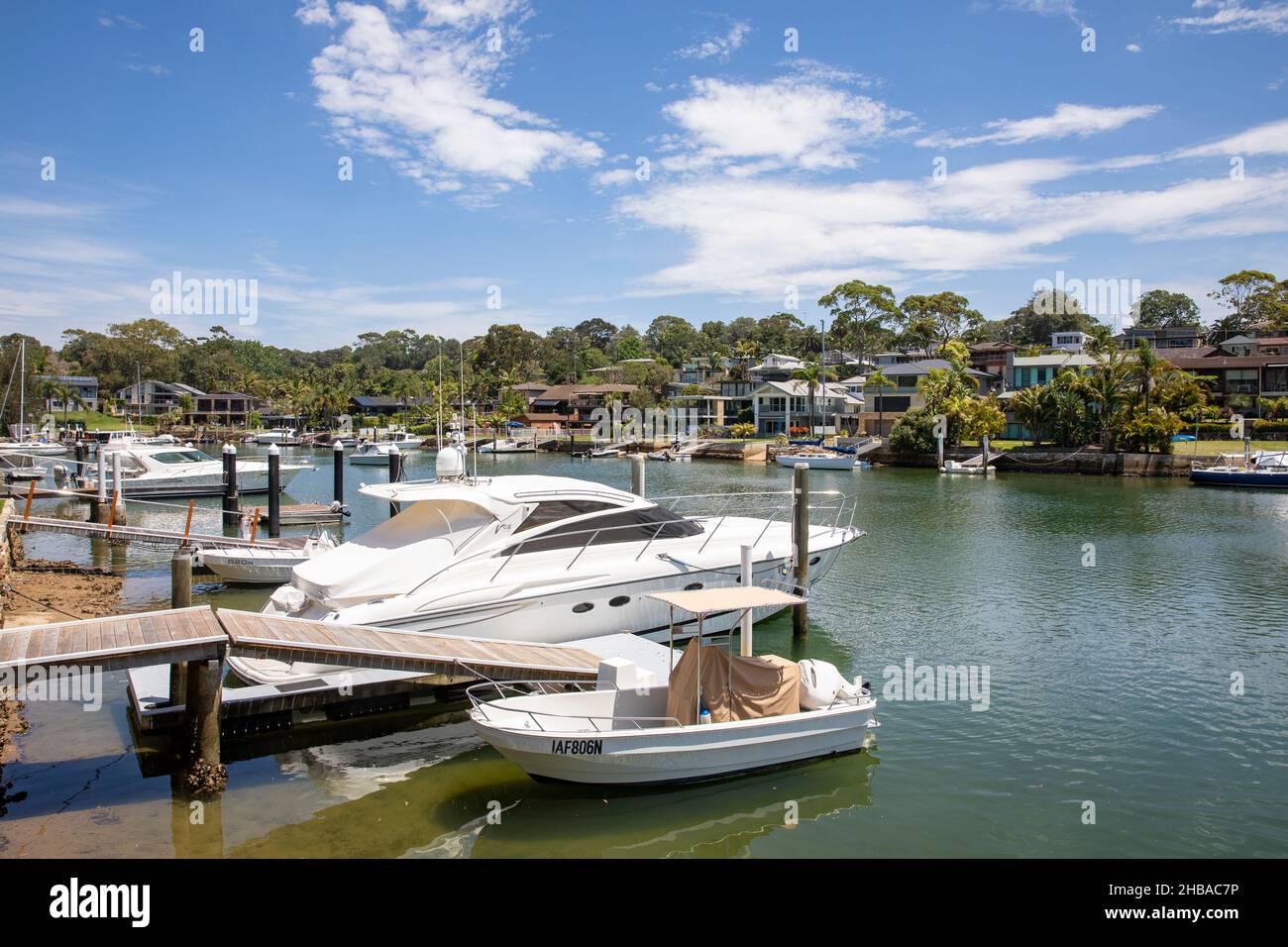 Häuser am Wasser in Newport Sydney, mit privaten Anlegestellen und Hausbesitzern mit ihren Booten, Pittwater, NSW, Australien Stockfoto