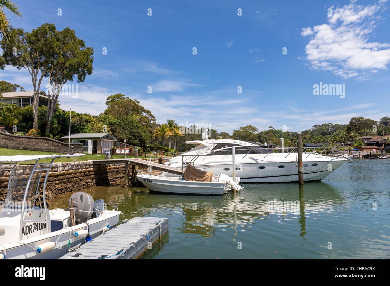 Häuser am Wasser in Newport Sydney, mit privaten Anlegestellen und Hausbesitzern mit ihren Booten, Pittwater, NSW, Australien Stockfoto