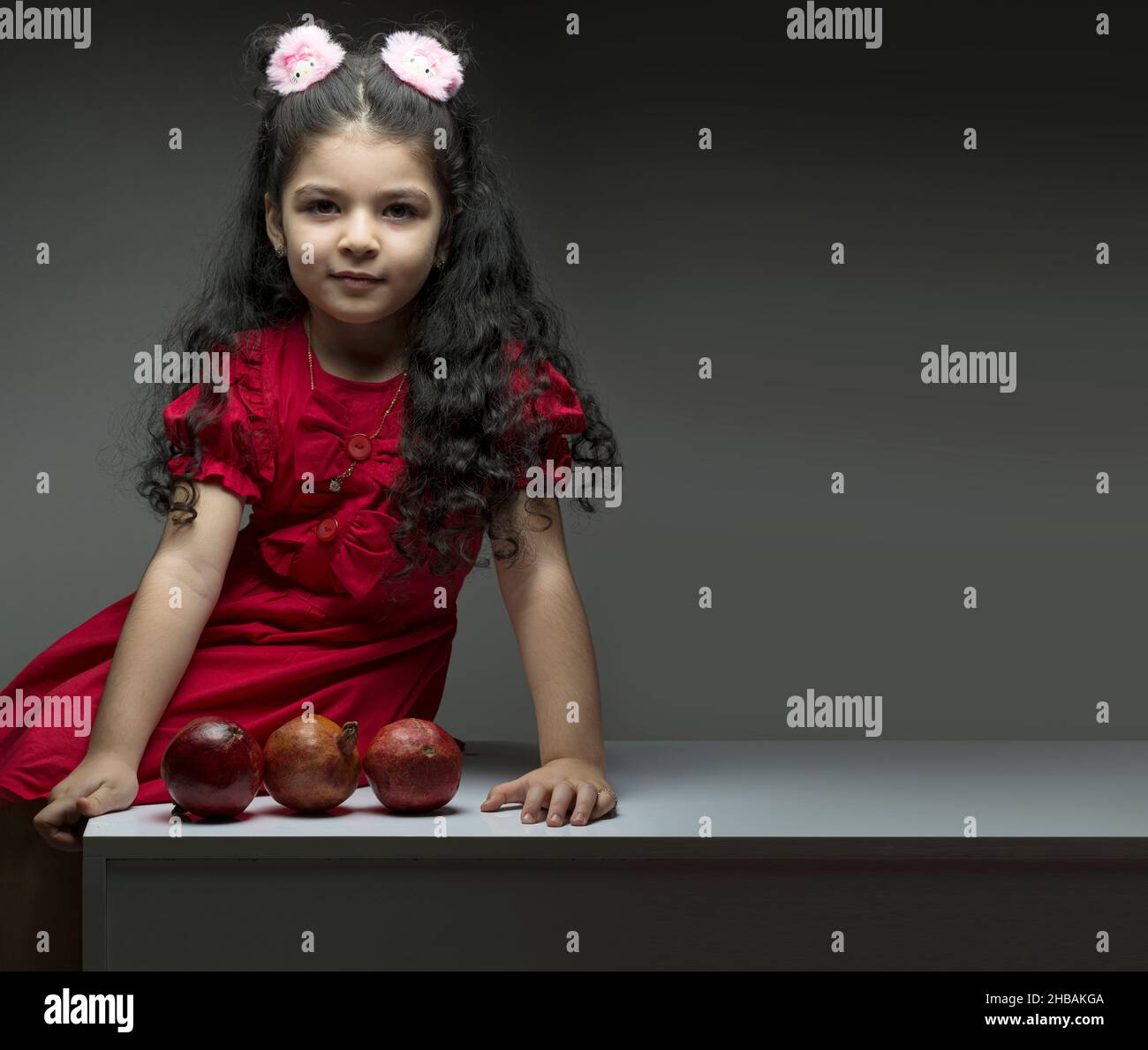 Kleines Mädchen mit drei Granatäpfeln vor ihr. Happy yalda iranische Feier Thema Stockfoto