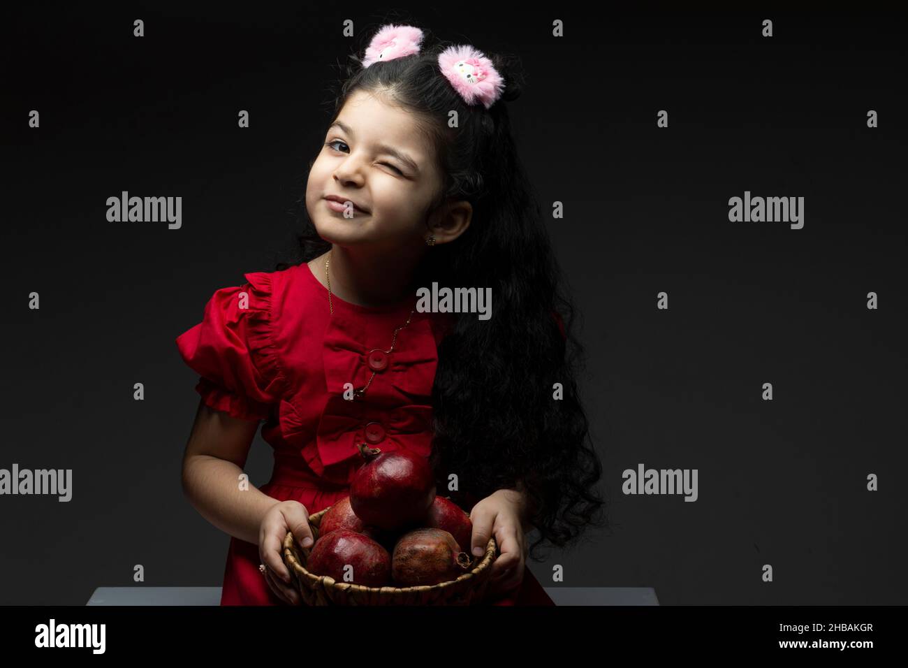 Zwinkerte Auge Mädchen mit Granatäpfel Korb vor ihr. Happy yalda iranische Feier Thema Stockfoto