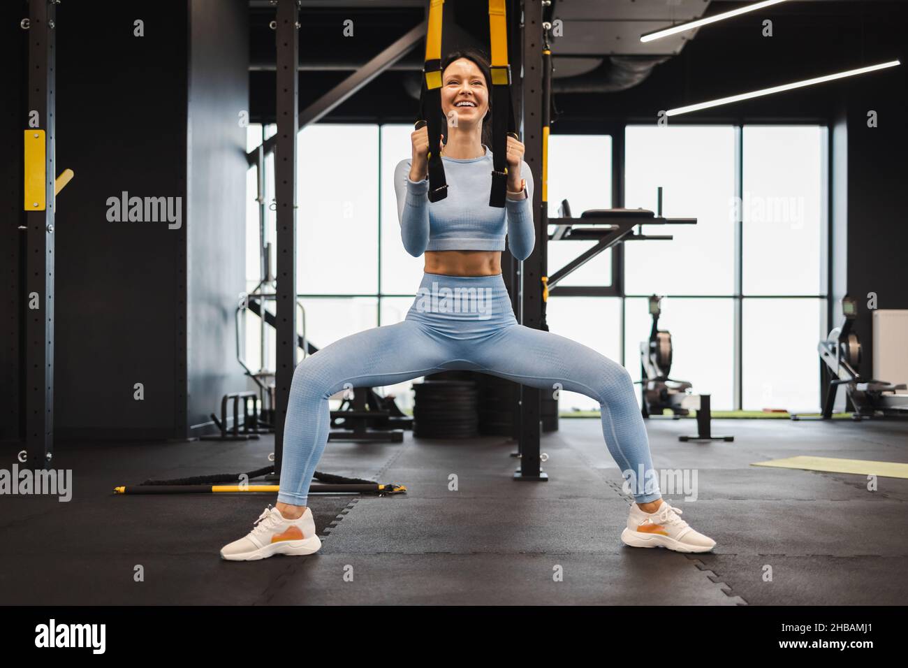 Frau trainiert mit Fitness-trx-Trägern im Fitnessstudio Stockfoto