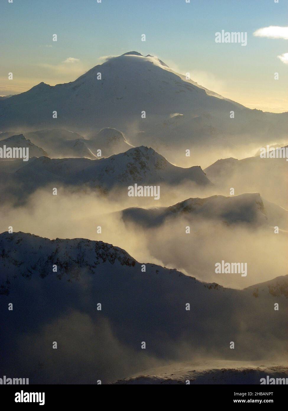 Ein nebliger Wintermorgen, Lake Clark National Park & Preserve. Tief liegende Wolken füllen die Täler zwischen Graten, die zu einem silhouettierten Redoubt-Vulkan führen. Mount Redoubt ist ein aktiver Stratovulkan im aleutischen Gebirge, Alaska, USA. Eine einzigartige, optimierte Version eines NPS-Bildes - Quelle: NPS/P. Spencer Stockfoto