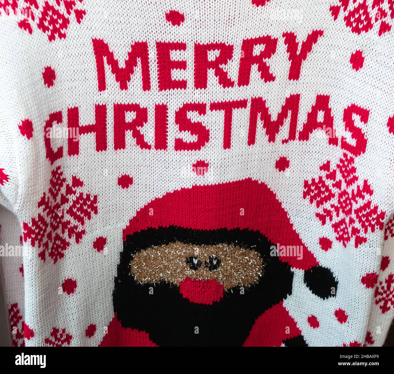 Handgefertigter Winterpullover aus Wollgestrick mit fröhlichen Weihnachtsgrüßen Stockfoto