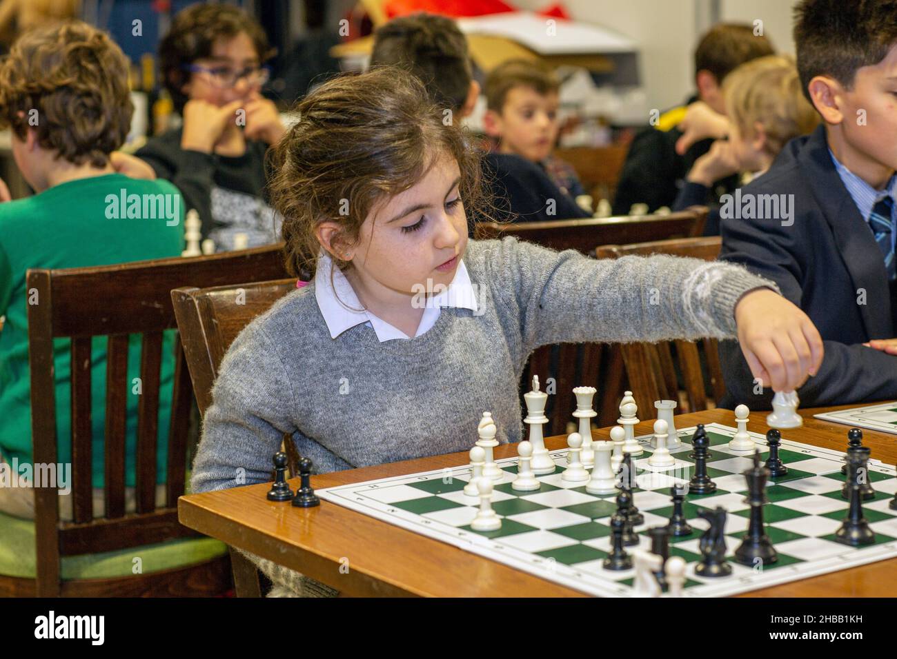 Intelligente Spiele. Ein Kind spielt Schach. Mädchen und ein Schachbrett. Strategie. Logisches Denken. Kleines Mädchen spielt Schach Stockfoto